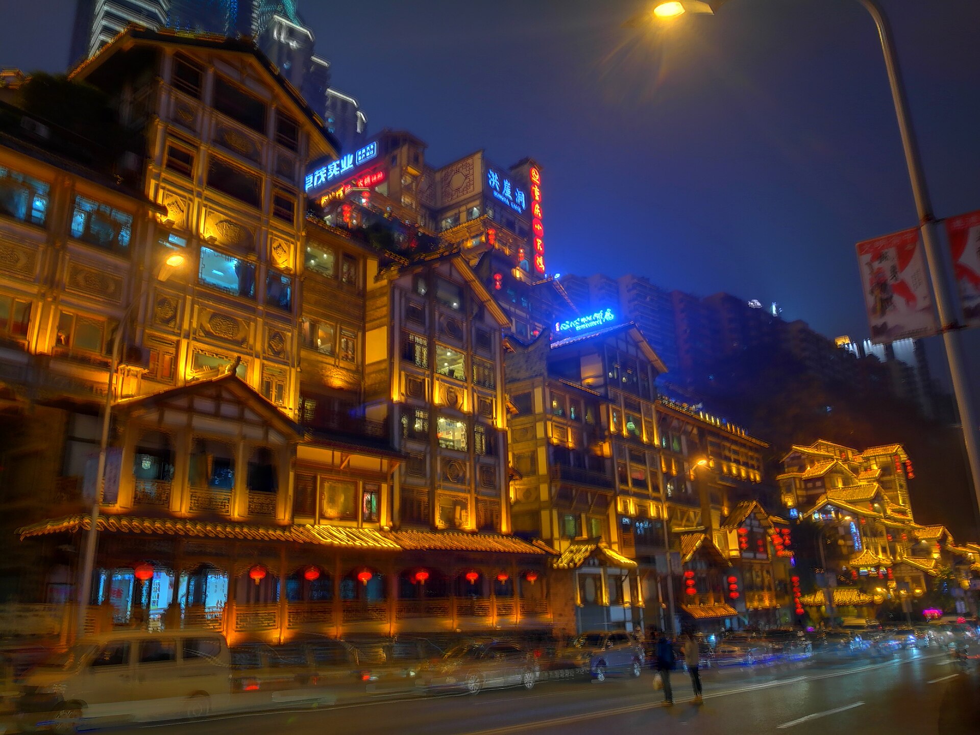 The stacked cliffside buildings of Hongya Cave lit gold at night, Chongqing