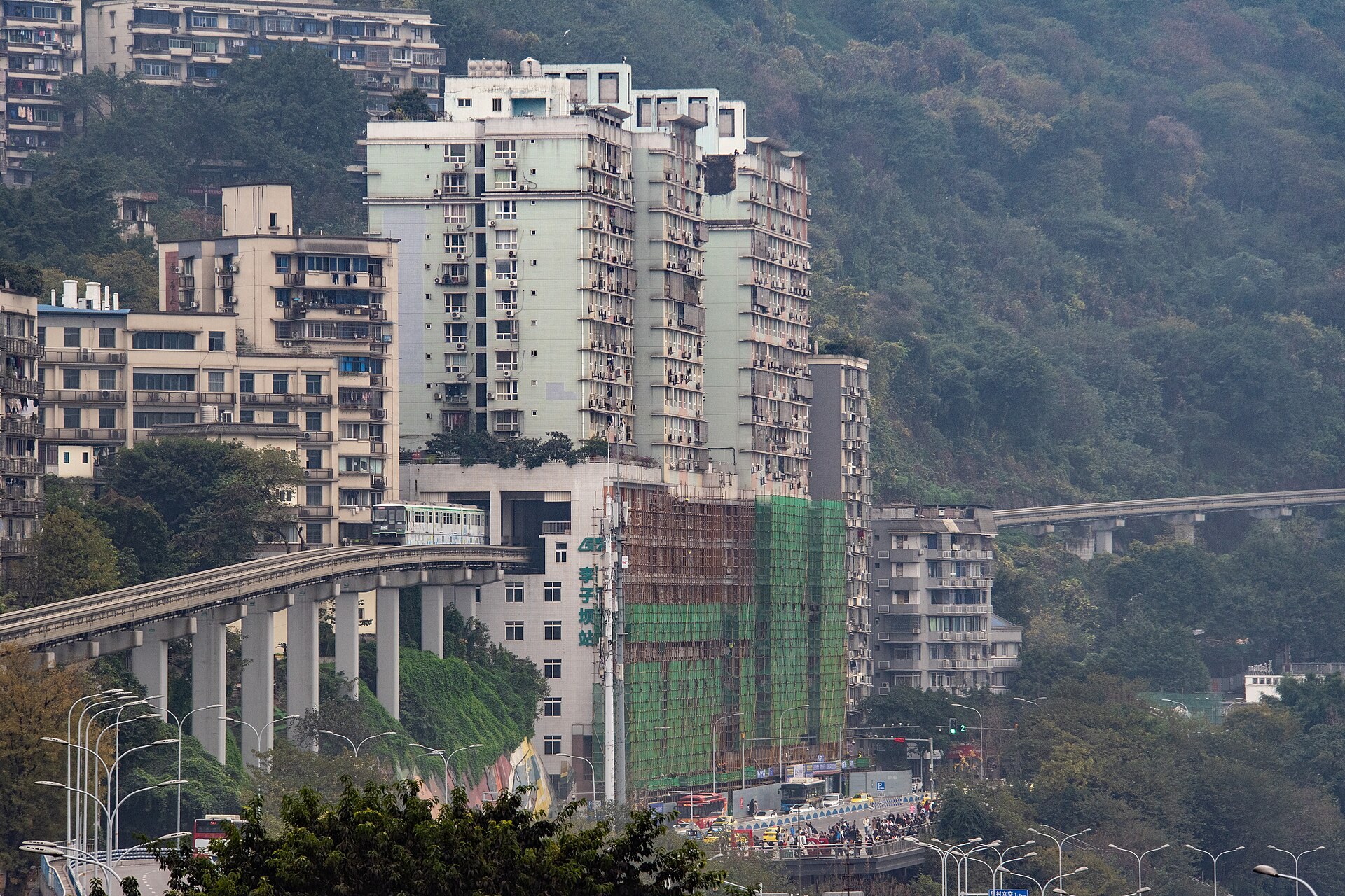 A Line 2 monorail train passing through the Liziba residential building above the viewing platform