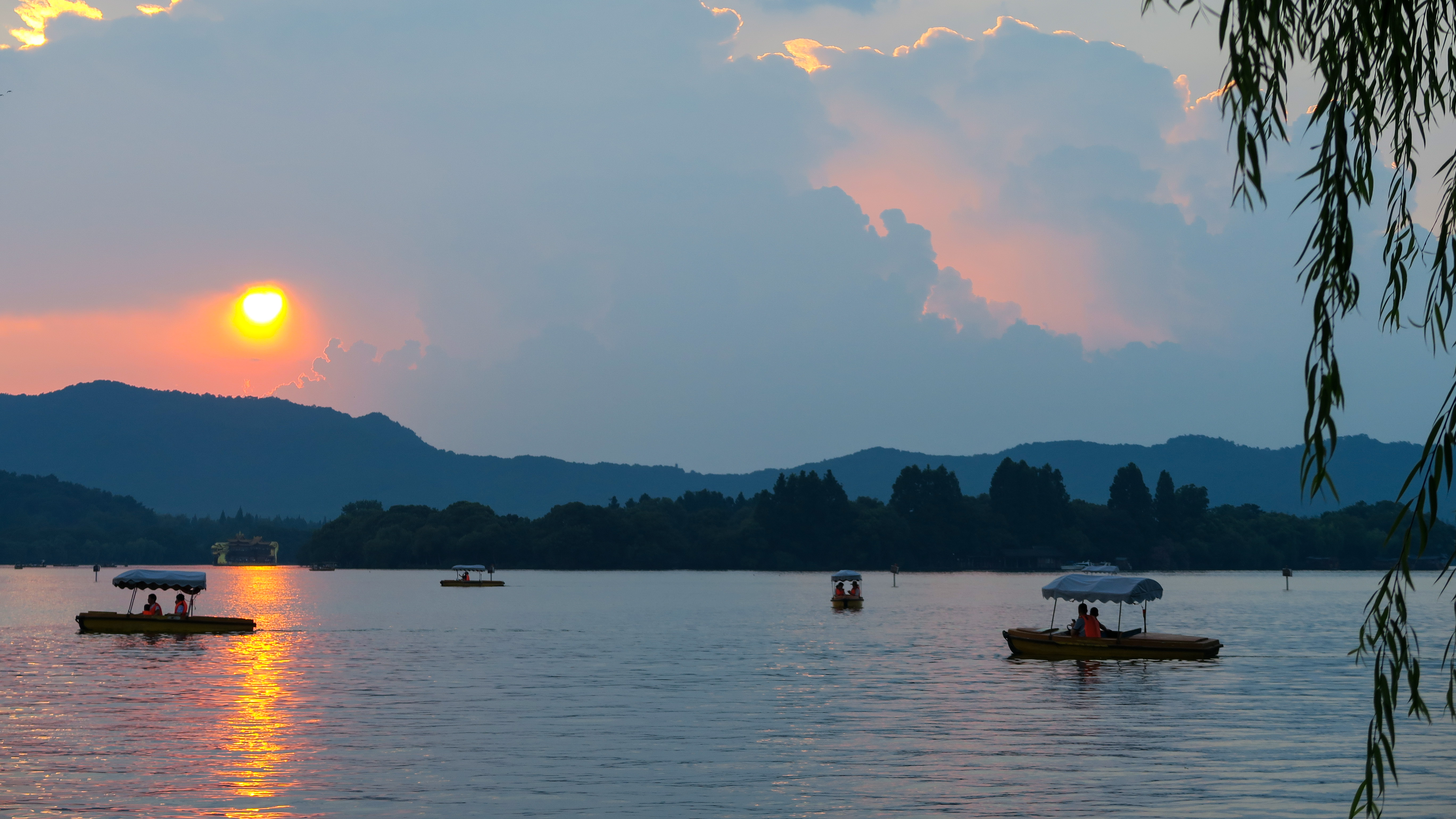 Canopied leisure boats on West Lake at sunset, willow fronds at the shore, Hangzhou