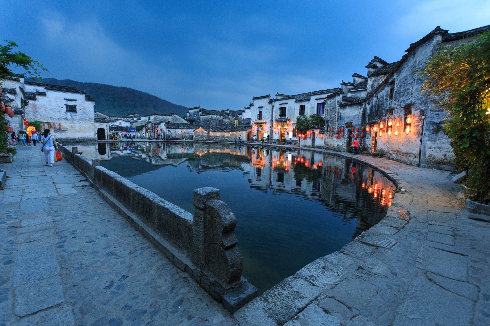 Hongcun's Moon Pond at dusk, white-walled Huizhou houses mirrored in the water