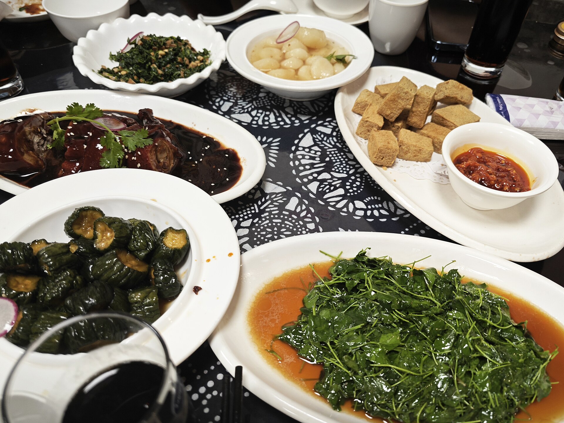 A full table of traditional Shanghainese benbang dishes in Pudong — braised pork in dark soy, greens and cold starters