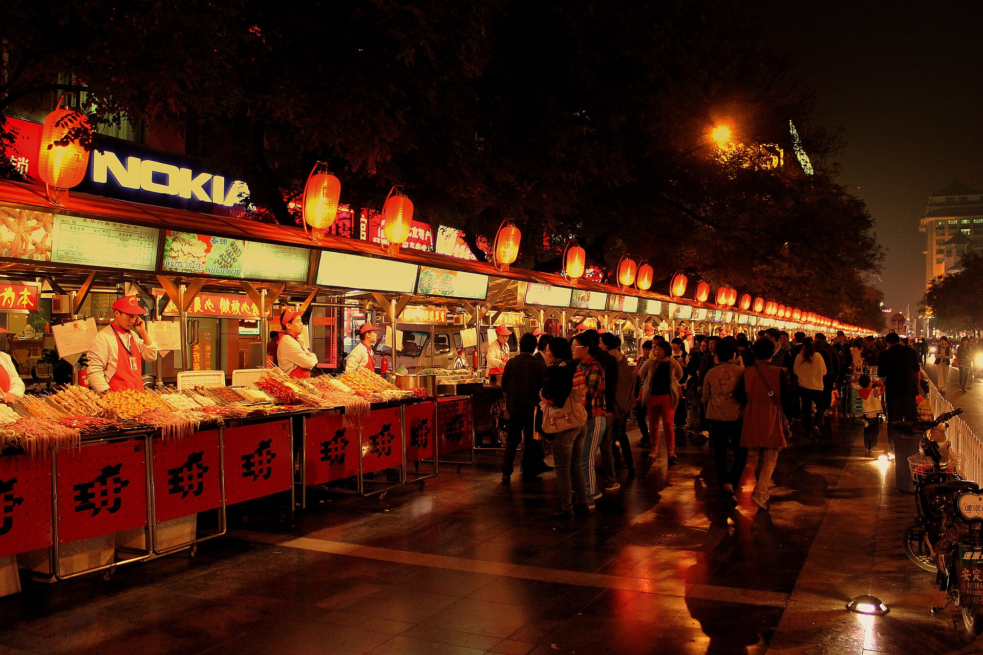 A Beijing night-market snack street at full stretch — dozens of stalls, one way to pay at every one of them