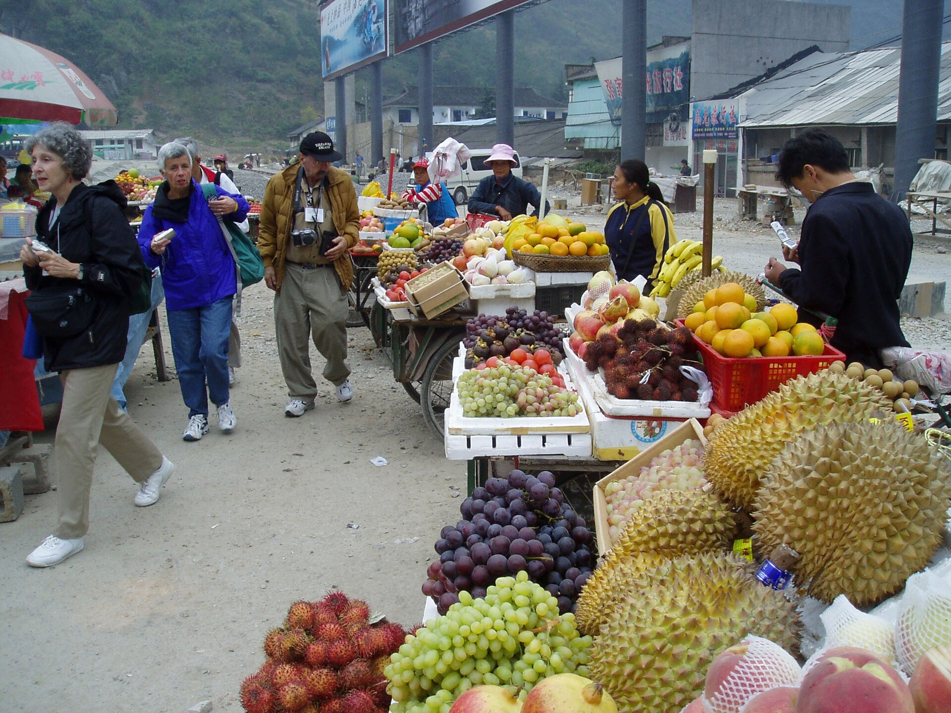 Travellers browsing fruit and produce stalls at a market near Zhangjiajie