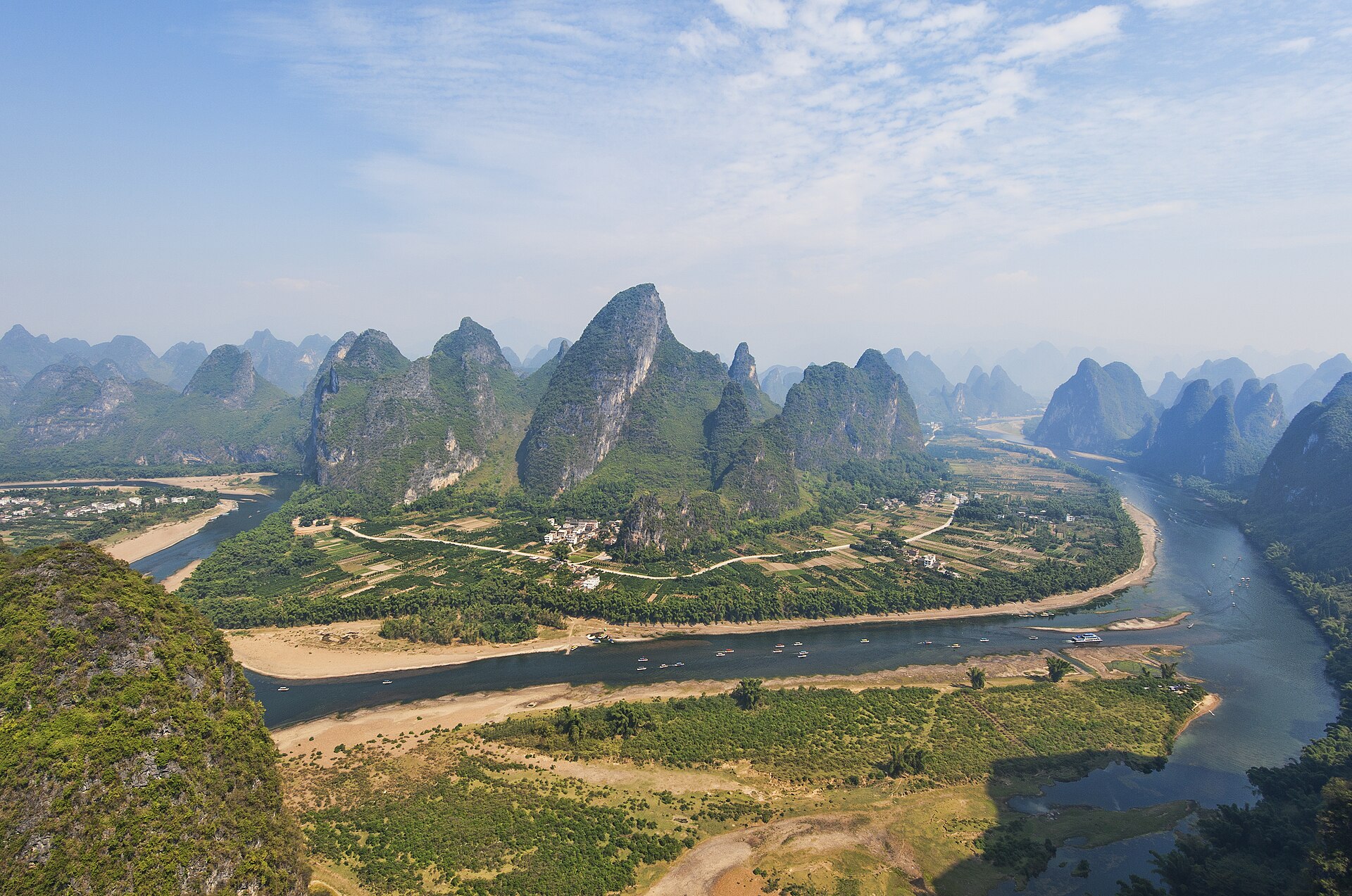 The Li River bending around karst peaks and farmland near Yangshuo, Guilin