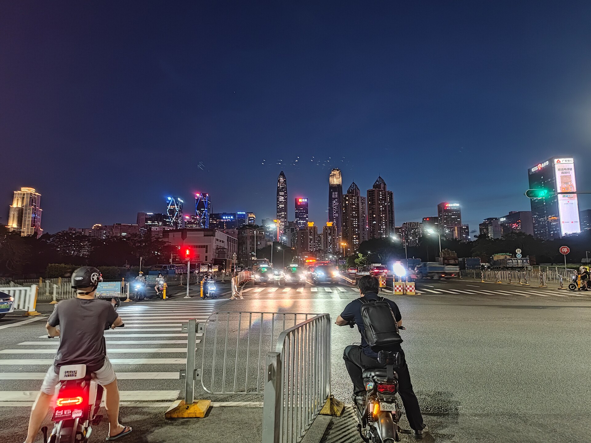 Dusk over a Shenzhen avenue as the Futian skyline, led by the Ping An Finance Centre, lights up