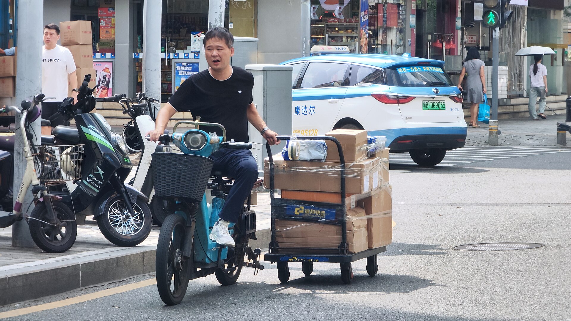A courier pulling a trolley of component parcels through Shenzhen's Huaqiangbei electronics district